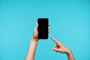 Un doigt pointant vers un téléphone