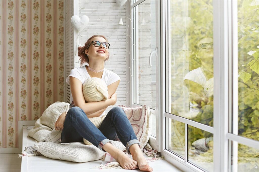 Jeune femme regardant par la fenêtre