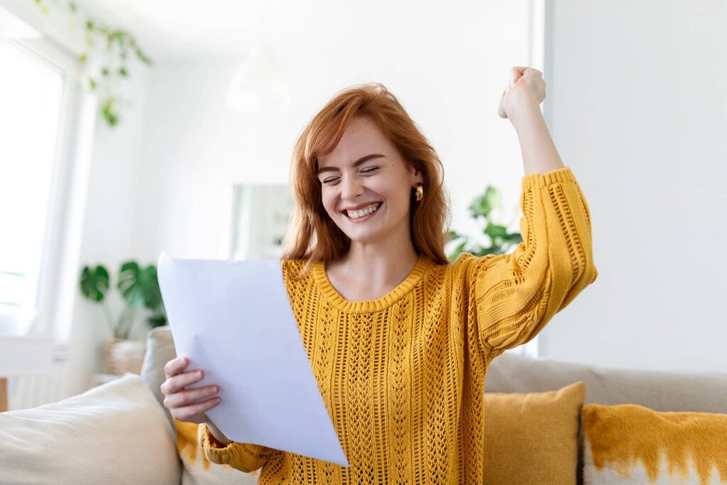 Jonge vrouw met die blij haar factuur bekijkt