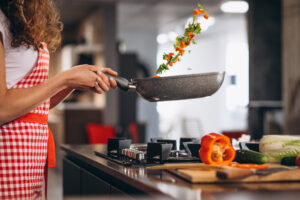 Femme tenant une casserole remplie de légumes
