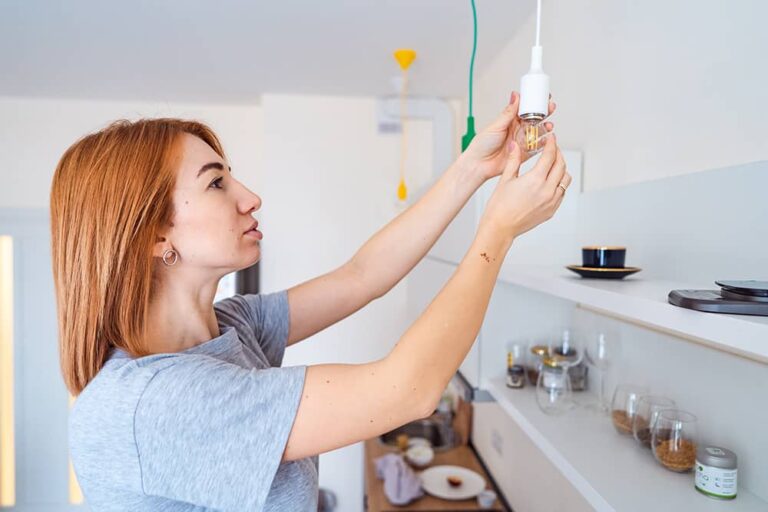 Une femme qui visse une ampoule